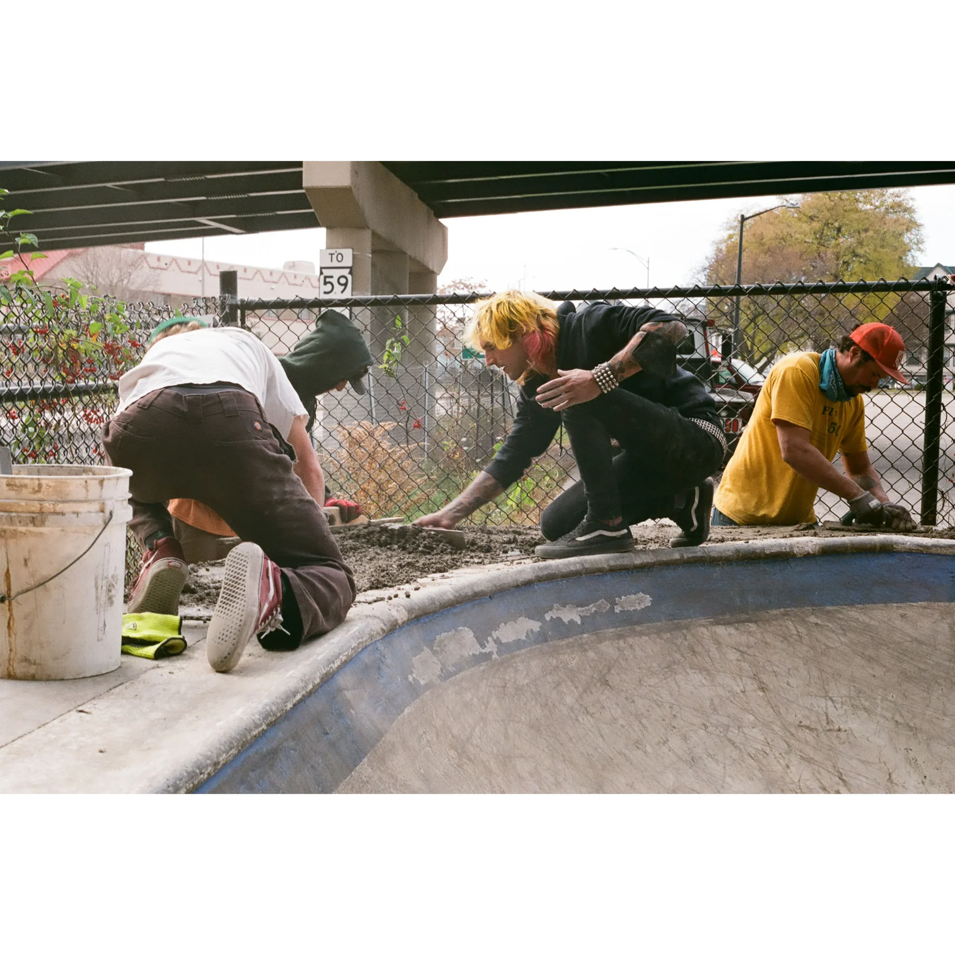 Skate community members finishing concrete on a new obstacle.